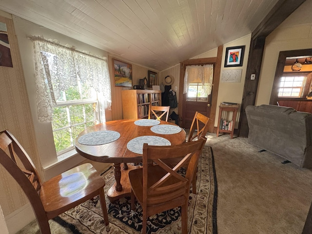 dining space featuring carpet, plenty of natural light, and vaulted ceiling
