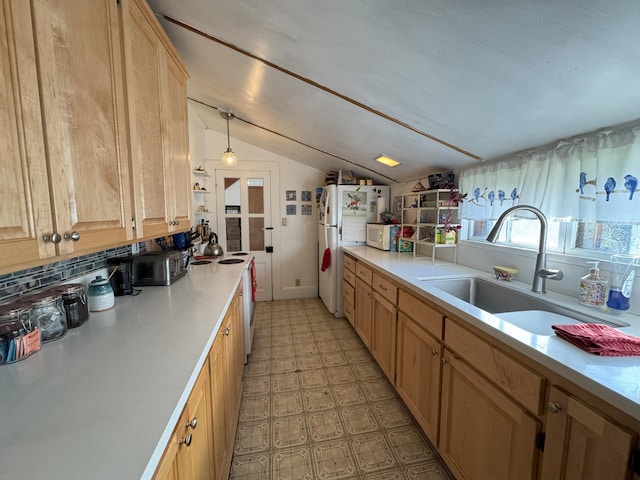 kitchen with white appliances, light floors, light countertops, vaulted ceiling, and a sink
