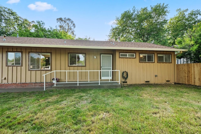view of front of house featuring a shingled roof, board and batten siding, crawl space, and fence
