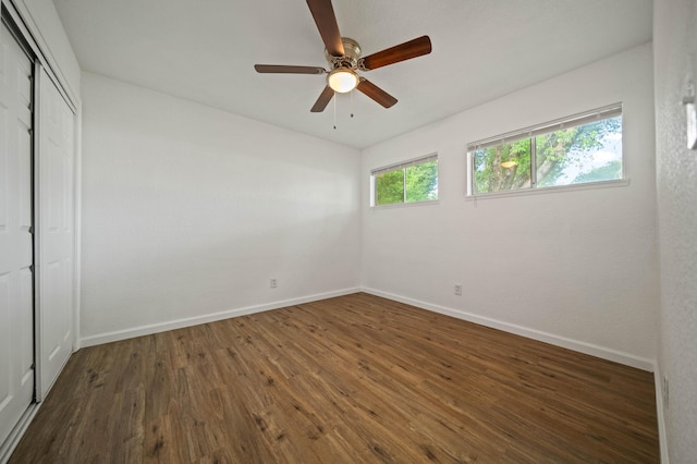 unfurnished bedroom with a closet, a ceiling fan, wood finished floors, and baseboards