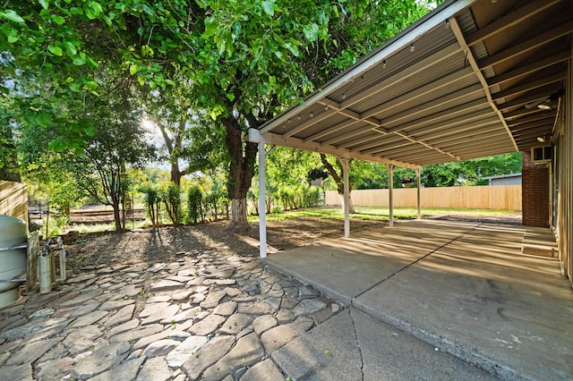 view of patio / terrace featuring fence and a carport