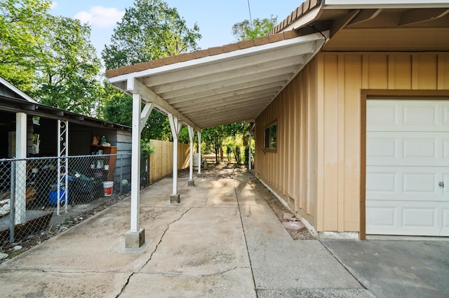 view of parking with concrete driveway and fence