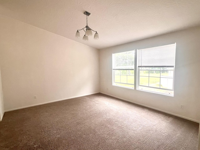 carpeted spare room featuring baseboards and a textured ceiling