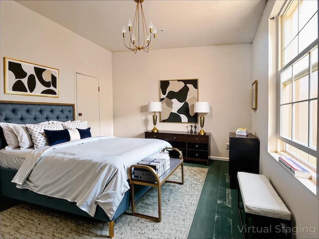 bedroom featuring a chandelier, baseboards, and wood finished floors