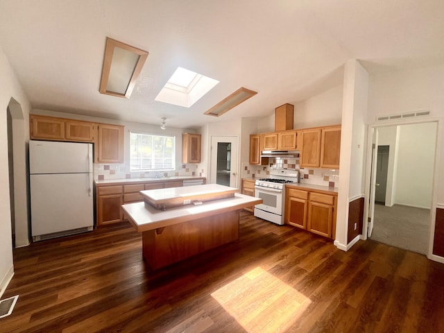 kitchen featuring decorative backsplash, white appliances, light countertops, and dark wood-style floors