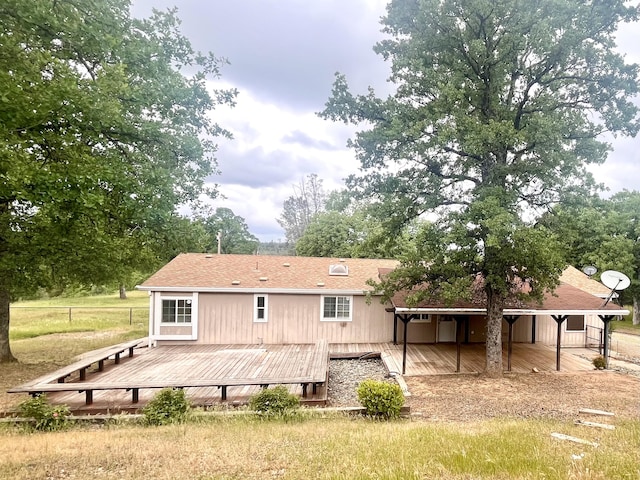 back of house with a carport and a wooden deck