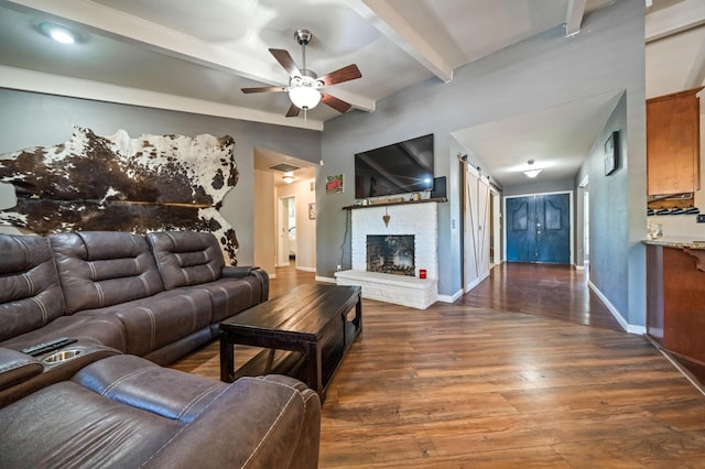 living area with a ceiling fan, visible vents, wood finished floors, baseboards, and beamed ceiling