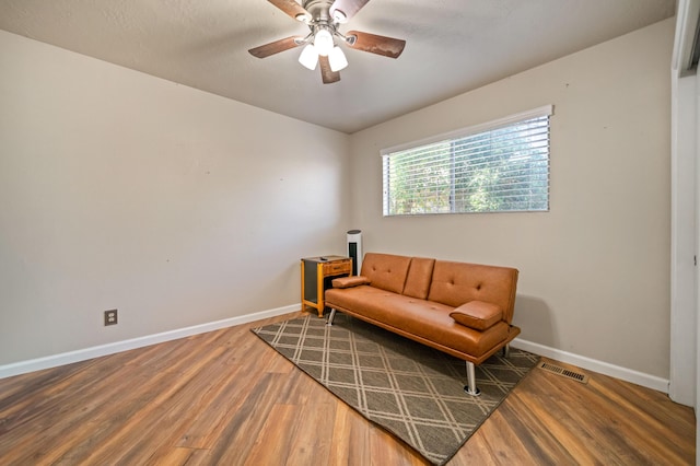 sitting room featuring visible vents, baseboards, ceiling fan, and wood finished floors