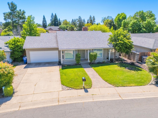 ranch-style house featuring a chimney, a front yard, a garage, fence, and concrete driveway