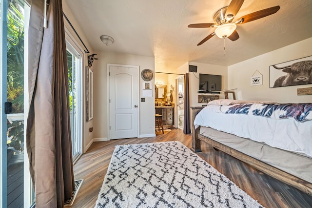 bedroom featuring baseboards, ceiling fan, wood finished floors, and visible vents
