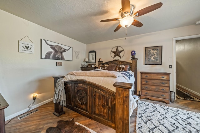 bedroom with visible vents, baseboards, ceiling fan, and wood finished floors