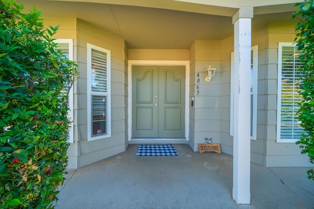 view of exterior entry featuring covered porch