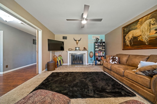 carpeted living room featuring a ceiling fan, baseboards, visible vents, and a fireplace