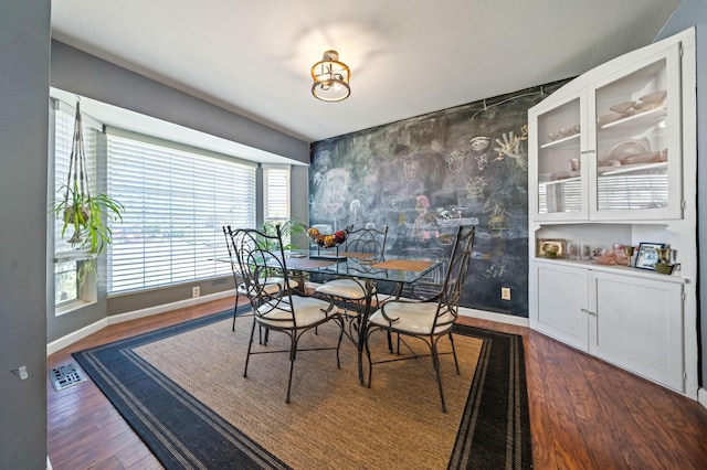 dining room with visible vents, dark wood-style flooring, and baseboards