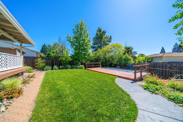 view of yard with a wooden deck and a fenced backyard