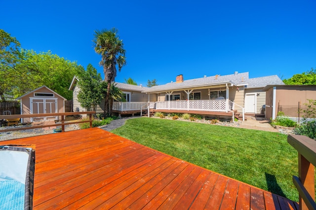 wooden deck with a storage unit, an outdoor structure, and a lawn