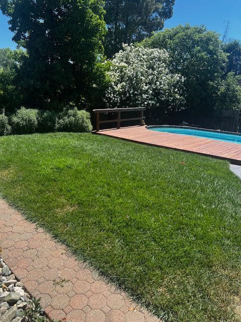 4065 Meander Dr, Redding, CA 96001 - view of grassy yard featuring a deck and an outdoor pool
