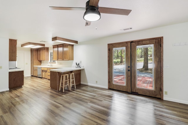 kitchen with light countertops, french doors, light wood finished floors, and a breakfast bar area