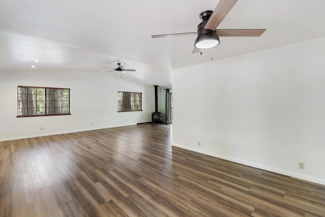 unfurnished living room featuring a wood stove, a ceiling fan, lofted ceiling, wood finished floors, and baseboards