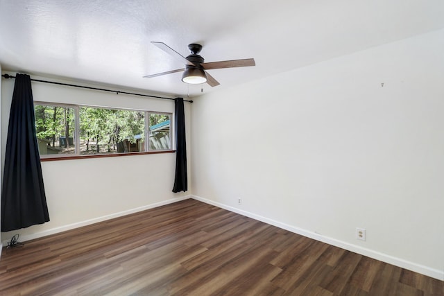 empty room with wood finished floors, ceiling fan, and baseboards