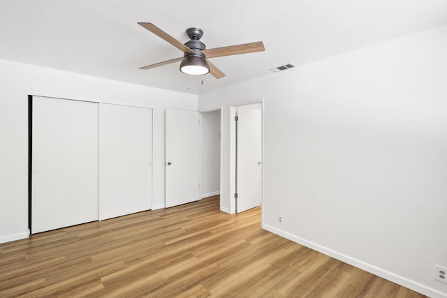 unfurnished bedroom with light wood-style floors, baseboards, a closet, and ceiling fan
