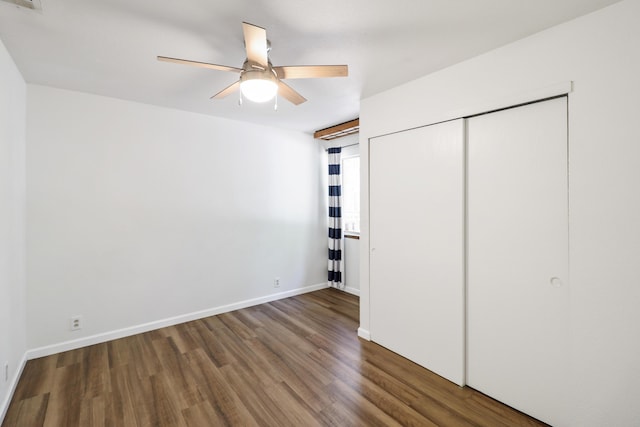 unfurnished bedroom featuring wood finished floors, baseboards, a closet, and ceiling fan