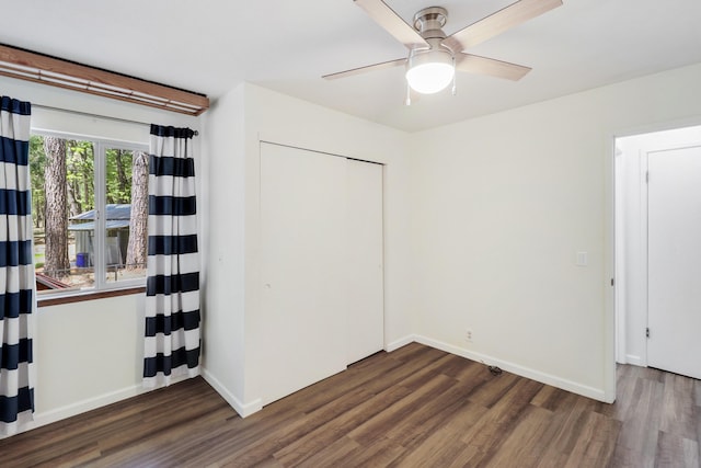 unfurnished bedroom with wood finished floors, baseboards, and a ceiling fan