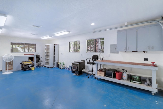garage featuring a wood stove, electric panel, and recessed lighting