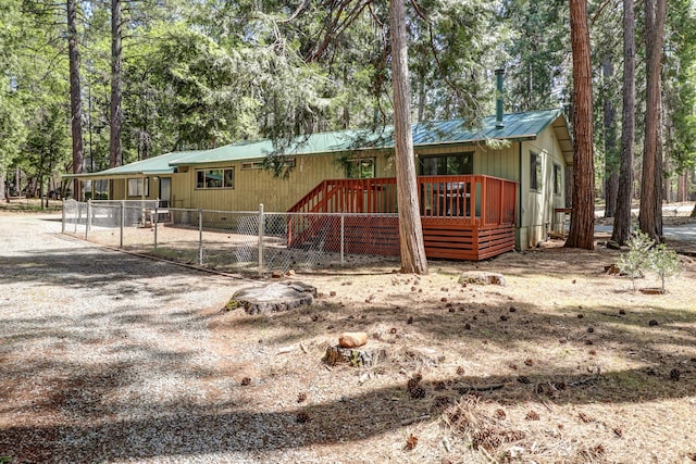 view of front facade featuring metal roof and view of wooded area
