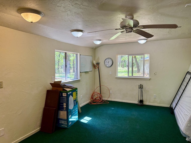 misc room with carpet flooring, a textured wall, baseboards, a textured ceiling, and ceiling fan