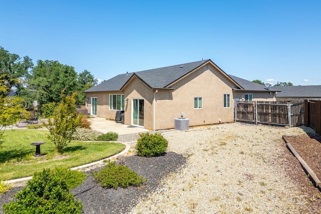 20295 Ballentine Dr, Anderson, CA 96007 - back of house featuring a gate, central AC, a fenced backyard, a patio, and stucco siding