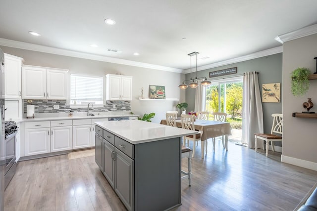 20295 Ballentine Dr, Anderson, CA 96007 - kitchen with decorative backsplash, a kitchen breakfast bar, a kitchen island, gray cabinetry, and white cabinetry