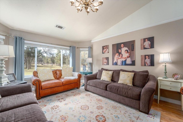 living room with a chandelier, visible vents, a healthy amount of sunlight, and lofted ceiling
