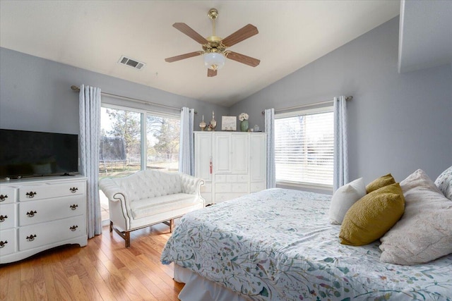 bedroom with visible vents, light wood-style flooring, ceiling fan, and lofted ceiling
