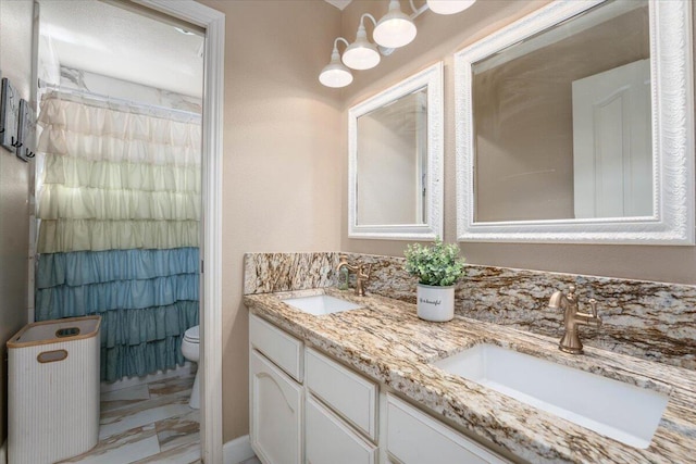 full bath with toilet, a shower with curtain, double vanity, and a sink