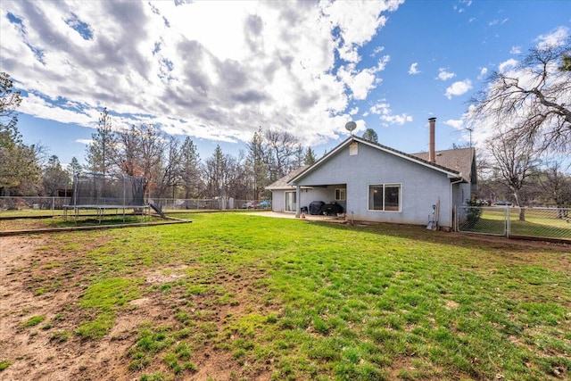 view of yard featuring a fenced backyard, a patio area, and a trampoline