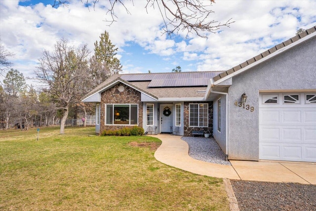 view of front of home with stucco siding, a garage, roof mounted solar panels, stone siding, and a front yard