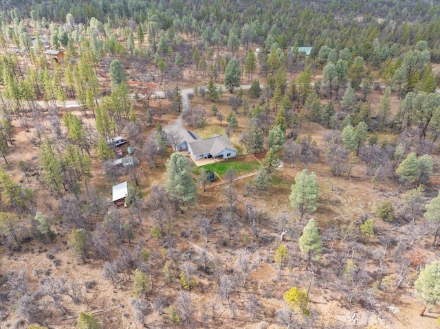 bird's eye view with a wooded view