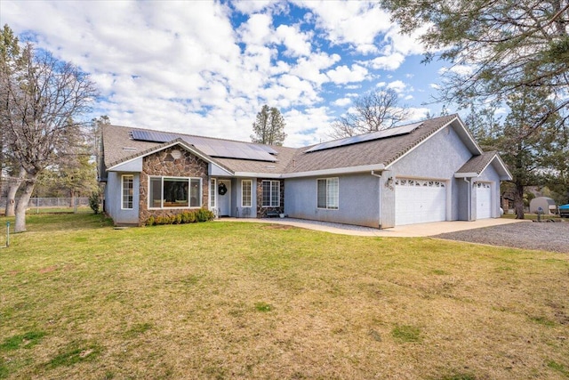 ranch-style house with fence, a garage, solar panels, driveway, and a front yard