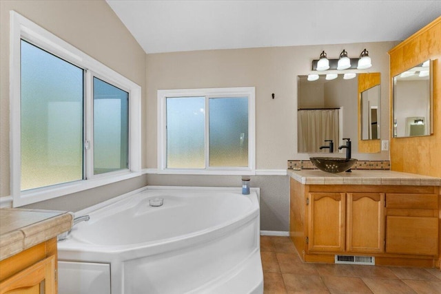 bathroom featuring vanity, a garden tub, tile patterned floors, and visible vents