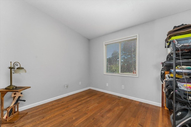 interior space featuring baseboards, visible vents, and wood finished floors