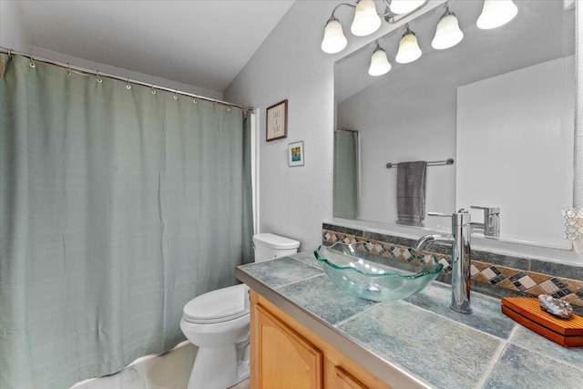 full bath featuring vanity, decorative backsplash, and toilet