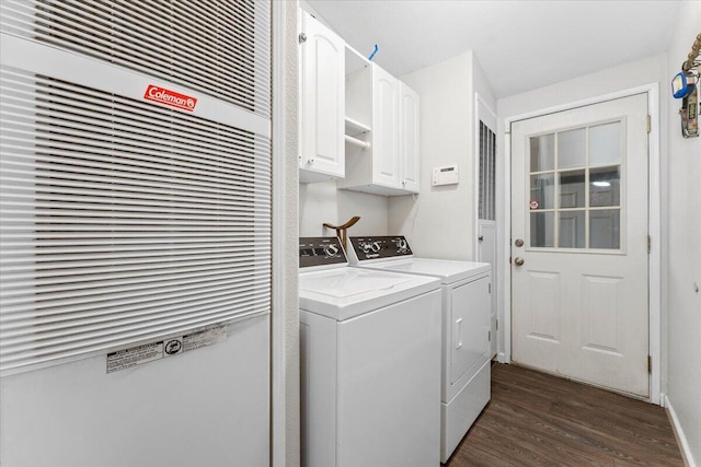 washroom with washing machine and clothes dryer, dark wood-style floors, cabinet space, and a heating unit