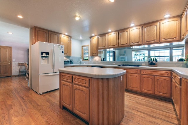 kitchen with light wood-type flooring, a healthy amount of sunlight, and white appliances