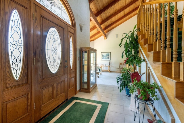 entrance foyer featuring beamed ceiling, stairway, high vaulted ceiling, wood ceiling, and light tile patterned floors