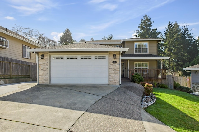 view of front facade with concrete driveway, covered porch, an attached garage, fence, and a front lawn