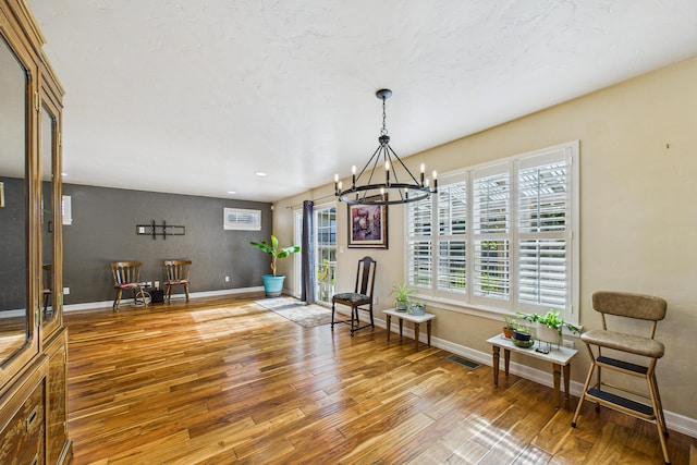 dining space with visible vents, baseboards, a chandelier, and wood-type flooring