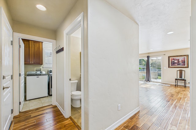 corridor with hardwood / wood-style flooring, washer and clothes dryer, recessed lighting, and baseboards