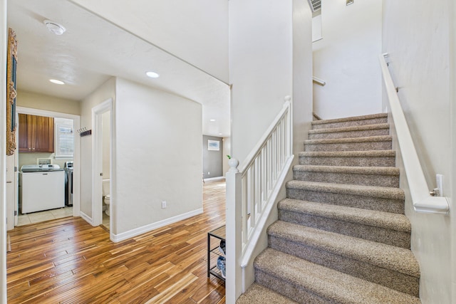 stairway featuring wood finished floors, recessed lighting, independent washer and dryer, and baseboards