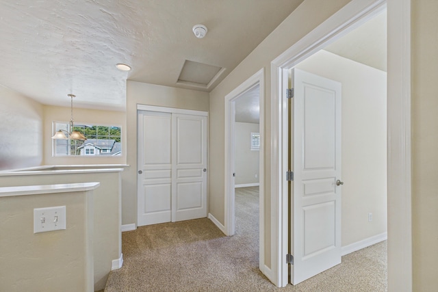 corridor featuring baseboards and carpet flooring